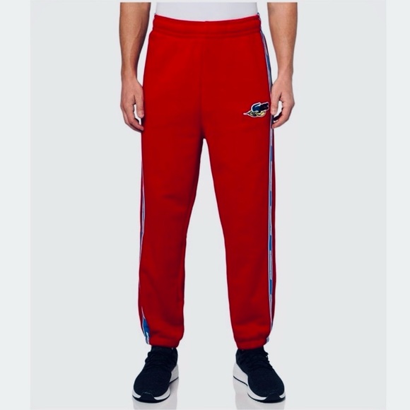 Lacoste NWT Men’s size medium red joggers with blue and yellow stripe accents.